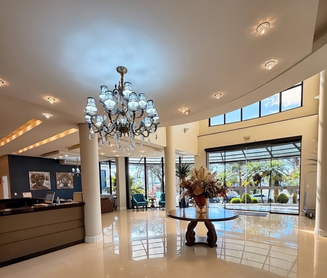 Saguão do Seville Park Hotel, com lustre de cristal e piso espelhado